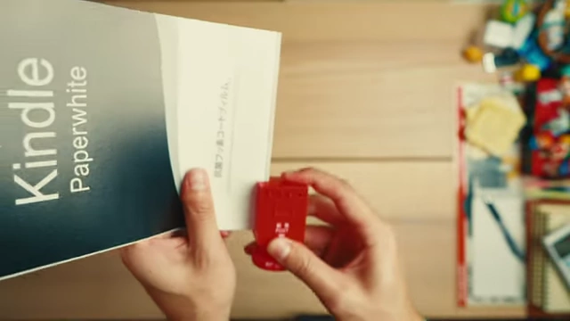 A person demonstrating how to use a red vintage Japan Post envelope cutter to open mail