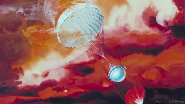 Artist's impression of an atmospheric probe descending with a parachute through colorful, cloudy alien skies, collecting data.