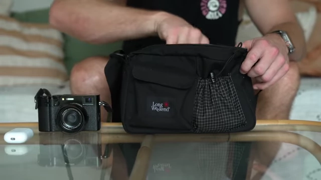A photography sling bag being prepared, showcasing its compact size and functionality for carrying a camera