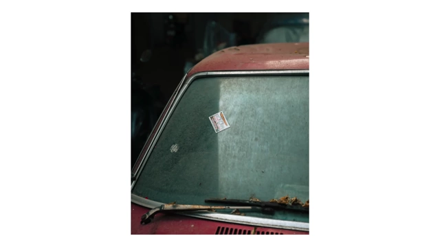 A detailed shot of a dusty car windshield with a sticker, capturing an everyday detail