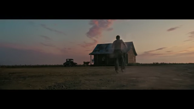 A character running towards a distant farmhouse at sunset, part of the film's visual narrative.