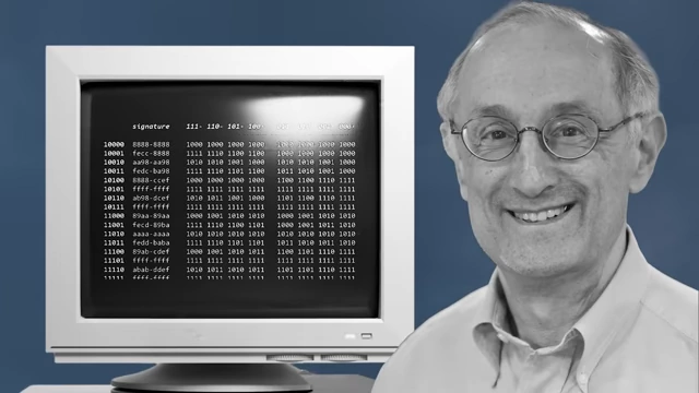 Political scientist Robert Axelrod next to a computer displaying code for his experiment