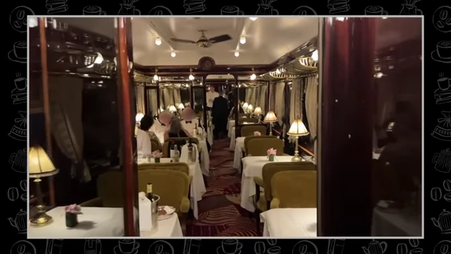 The elegant dining car of a luxury train, with finely set tables and chandeliers.
