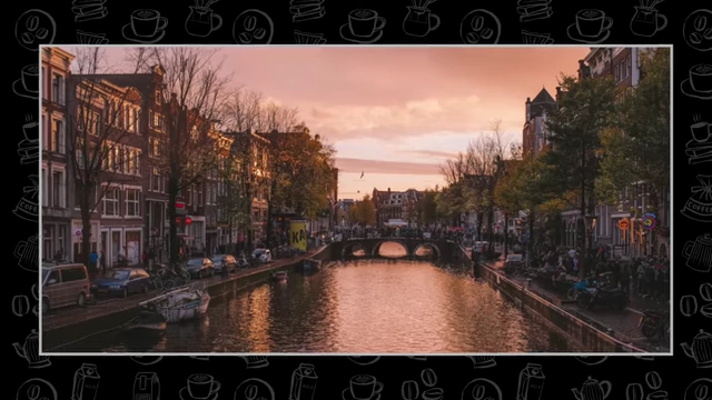 A canal scene in Amsterdam at sunset, with traditional European buildings lining the water.
