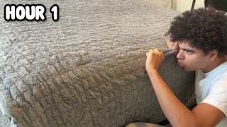 The presenter comically 'measuring' his bed with a pen, with the text "HOUR 1" overlaid.