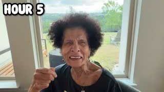 The presenter's grandmother looking directly at the camera with an exasperated expression, demanding food.