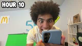 The presenter making a shocked and dramatic face while holding his phone, with the text "HOUR 10" overlaid.