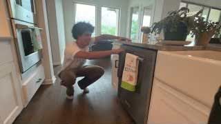 The presenter dramatically closing an empty dishwasher.