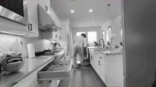 The presenter walking through his kitchen, which is now in black and white, to emphasize his changed perspective.