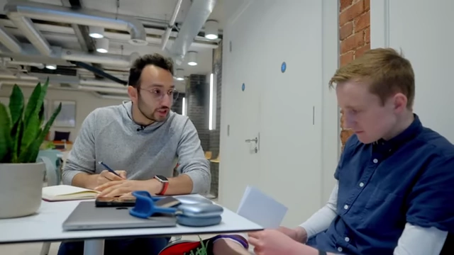 Ali Abdaal collaborating with an in-person team member.