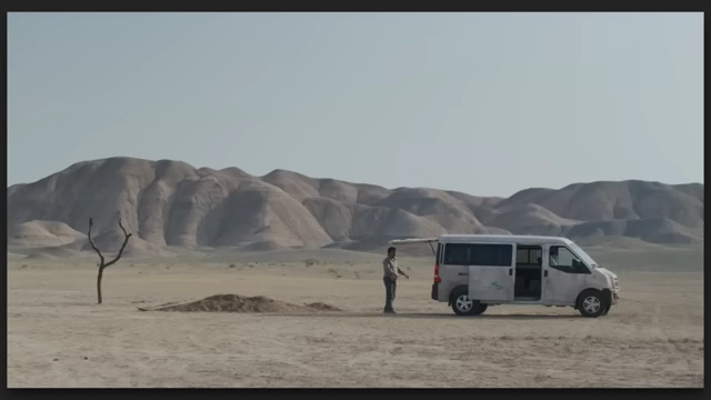 A white van in a desert landscape with a single tree in "It was Just an Accident."