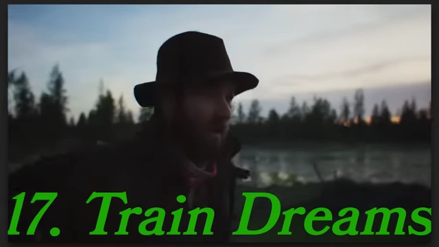 A man in a hat looking out over a body of water at dusk in "Train Dreams."