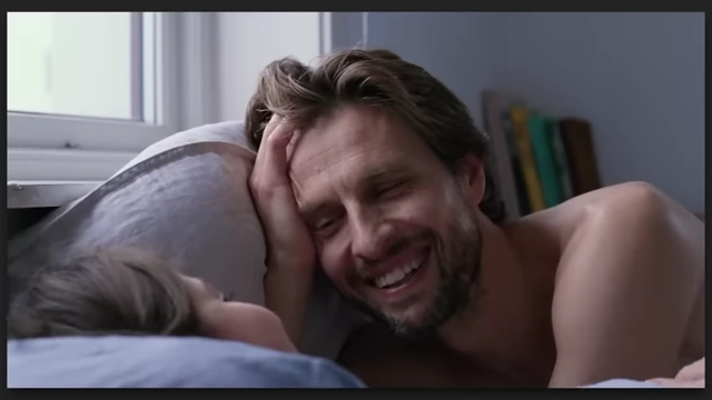 A man and a woman in bed, sharing an intimate, happy moment in "Sentimental Value."