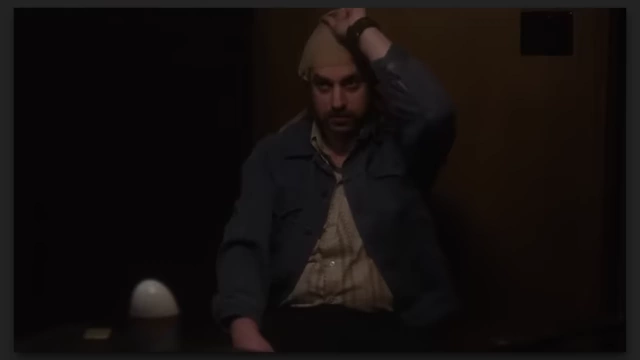 A man with a stocking over his head, a visual representing the crime film aspect in "The Mastermind."