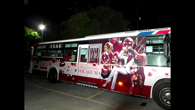 A bus adorned with Vox Akuma birthday artwork, showcasing his real-world popularity and marketing.