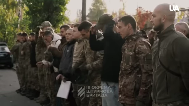 Ukrainian soldiers standing in formation, some in civilian attire
