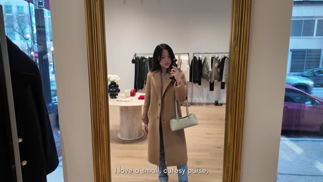 The speaker trying on a small, cutesy purse in a store, illustrating impractical bags.