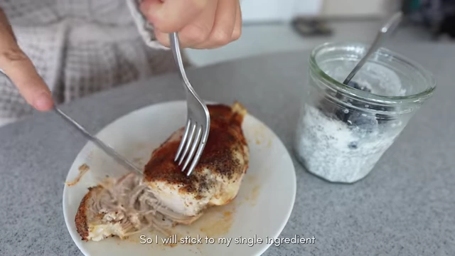 The speaker cutting a piece of chicken on a plate next to a jar of chia pudding, illustrating single-ingredient whole foods.