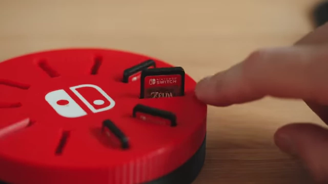 A red 3D printed Nintendo Switch cartridge holder with games inserted.