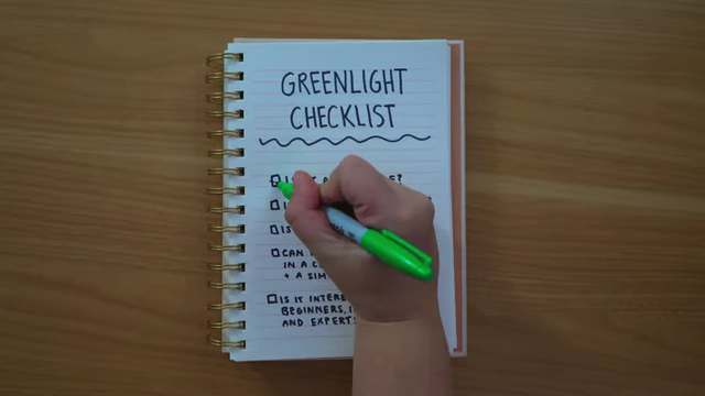 A hand checking off items on a "Greenlight Checklist" in a notebook