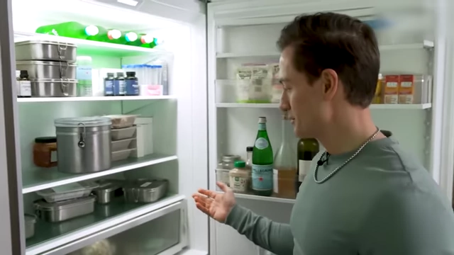 A refrigerator stocked with food in stainless steel containers, minimizing plastic use.