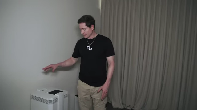 Bryan Johnson stands next to a commercial-grade air purification system in his bedroom.