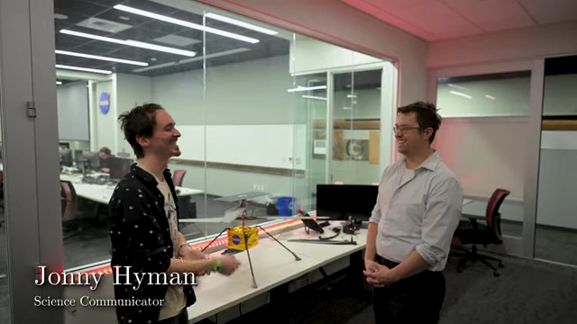 Jonny Hyman, identified as a Science Communicator, standing in an office, an early and talented hire for Veritasium.