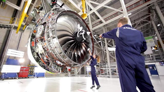 A close-up view of a large, intricate jet engine under construction or maintenance, from a Veritasium video.