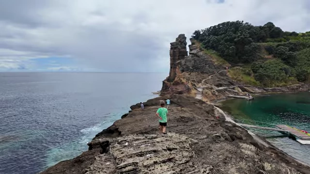 A child walking along a rocky coastline next to the ocean, illustrating Derek Muller's increased family time and travel.