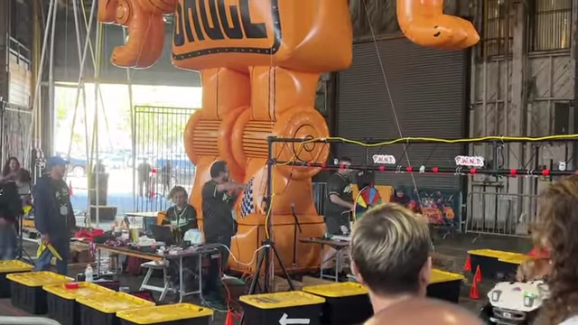 An orange inflatable giant robot overseeing a small car race area.