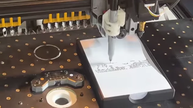 Robot arm drawing on a piece of paper in the creator museum.