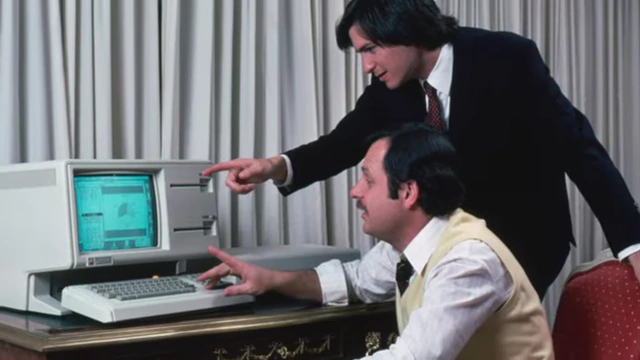 Steve Jobs interacting with John Couch next to a Lisa computer
