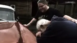 A man embraces his newly gifted 1955 Chevrolet, overcome with emotion.