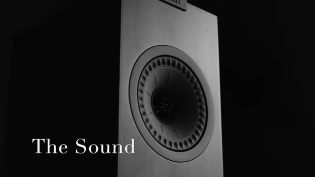 A KEF Q150 speaker in a living room environment with the words "The Sound" overlaid.