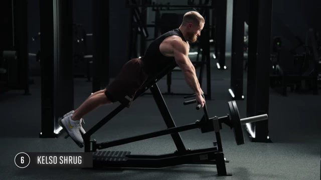 Man performing Kelso shrugs on a T-bar row machine, emphasizing locked arms and shoulder blade movement