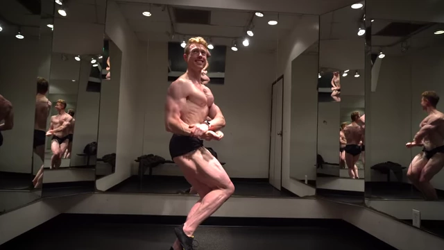 The speaker posing in a natural bodybuilding competition, providing context for his extreme leanness.