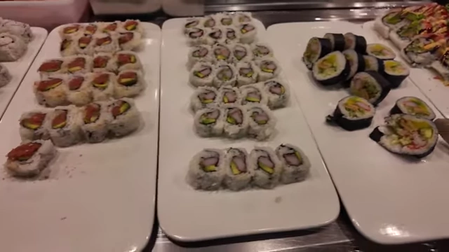 Assortment of sushi rolls, some with avocado and tempura batter.