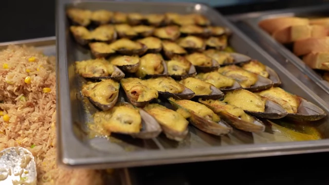 Baked mussels topped with cheese and mayo.