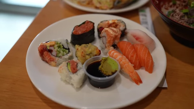 A selection of sushi including salmon and hamachi nigiri and spicy tuna rolls.