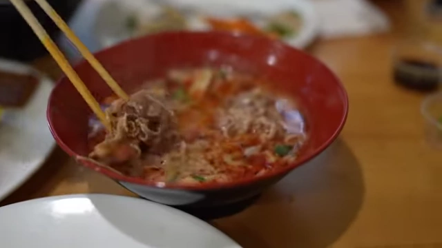 A Malatang bowl with extra spicy mala broth, lamb, and enoki mushrooms.