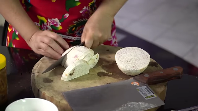 Slicing taro to approximately 1cm thickness.