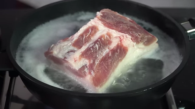 Pork belly blanching in boiling water.