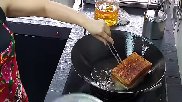 Pork belly skin frying to a golden brown and crispy texture.