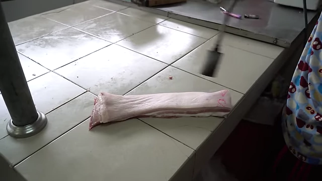 Butcher singeing pig hair to remove bristles.
