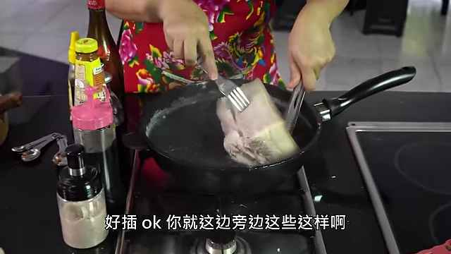 Piercing pork belly skin with a fork to ensure even crisping.