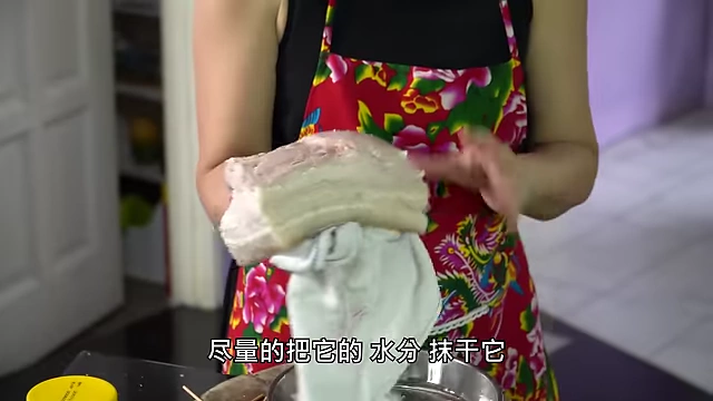 Wiping the pork belly skin dry after salting.