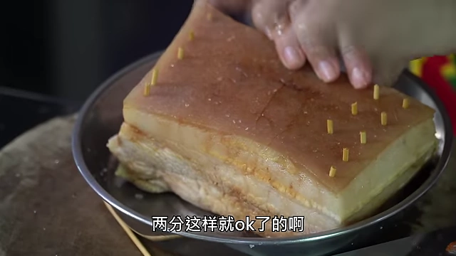 Inserting bamboo sticks to prevent pork belly from curling during frying.