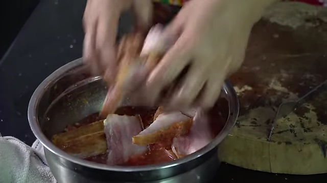Coating pork belly slices thoroughly in the prepared sauce.