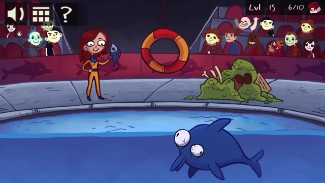 The dolphin looks sick with a pile of green mess floating in the water next to it