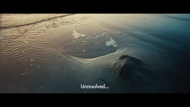 Waves gently recede on the beach, with "Unresolved..." text overlayed, encapsulating the film's ambiguous conclusion.